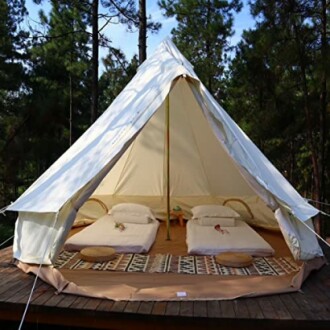 Glamping-Zelt im Wald mit zwei Betten.