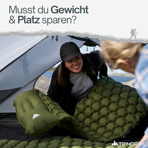 Person in einem Zelt mit aufblasbarer Campingmatte