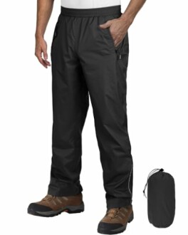 Mann trägt schwarze wasserdichte Regenhose mit Stiefeln.