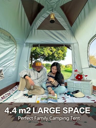 Familie liest in großem Campingzelt.
